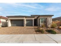 Charming single-story home featuring a brick driveway, two-car garage and desert landscaping at 8934 Windgate Ranch St, Las Vegas, NV 89166