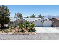 Charming single-story home with a well-manicured front yard and a two-car garage at 901 E Jaybird St, Pahrump, NV 89048