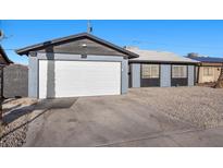 Single story home featuring a gray exterior, a two-car garage, and desert landscaping in the front yard at 2088 Miner Way, Las Vegas, NV 89104