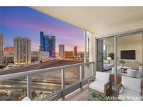 Relax on this balcony featuring chairs and a view of the cityscape in the background at 222 Karen Ave # 1702, Las Vegas, NV 89109