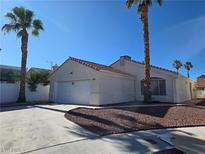 Charming single-story home featuring stucco siding, a red tile roof and lush desert landscaping at 6636 Old Oxford Ave, Las Vegas, NV 89108