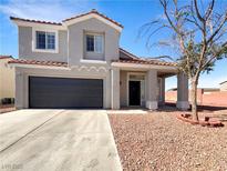 Two-story home featuring a two-car garage, low maintenance landscaping, and a covered front porch at 6696 Merced Lake Dr, Las Vegas, NV 89156