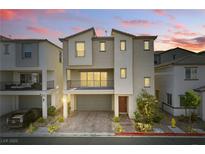 Two-story home with a front yard, balcony, brick driveway, and two car garage at 6850 Magenta Moon St, North Las Vegas, NV 89086