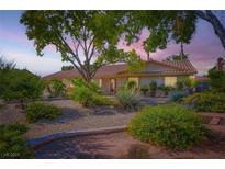 Charming home featuring desert landscaping, trees, and a tiled roof providing a welcoming exterior at 7385 Severence Ln, Las Vegas, NV 89131
