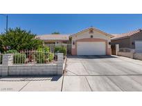 Charming single-story home featuring a well-manicured front yard and attached two-car garage at 1110 Orchard Valley Dr, Las Vegas, NV 89142