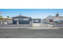 Modest single-story home with a gated front yard providing security and curb appeal at 2721 Merritt Ave, Las Vegas, NV 89102