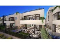 Stunning modern home with a large patio, outdoor seating, and a glimpse of the open-concept interior at 32 Heron Harbour Dr, Henderson, NV 89011