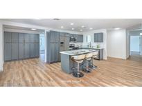 Modern kitchen with gray cabinets, stainless steel appliances, and a sleek island with bar seating at 6517 Villa Mesa Dr, Las Vegas, NV 89107