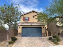 Two-story home with a large blue garage door and a charming desert landscape at 6682 Salt Pond Bay St, Las Vegas, NV 89149