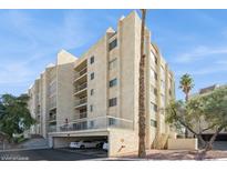View of condo complex, boasting private balconies, covered parking, and desert landscaping against a blue sky backdrop at 745 N Royal Crest Cir # 157, Las Vegas, NV 89169