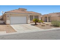 Charming single-story home featuring a two-car garage, low maintenance landscaping, and a tile roof at 820 Peach Ave, North Las Vegas, NV 89032