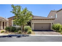 Inviting single-story home featuring a two-car garage, stone accents, and desert landscaping at 832 Gallery Course Dr, Las Vegas, NV 89148