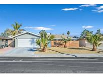 Charming single-story home featuring a well-maintained lawn with mature palm trees and an attached two-car garage at 105 Shadow Ln, Las Vegas, NV 89106