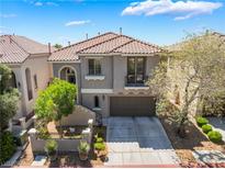 Two-story home featuring a tile roof, gray stucco exterior, and a two car garage at 11901 Luna Del Mar Ln, Las Vegas, NV 89138
