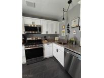Well-lit kitchen with granite countertops, stainless steel appliances and white cabinetry at 2456 Desert Butte Dr, Las Vegas, NV 89134