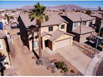 Two-story home showcasing a desert-landscaped front yard, tile roof, and a two-car garage at 5308 Hollyridge St, North Las Vegas, NV 89081