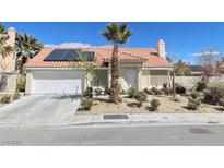 Charming single-story home featuring desert landscaping, solar panels, and a two-car garage at 5870 Grey Wood Way, North Las Vegas, NV 89031