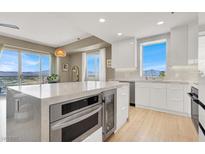 Bright, modern kitchen features an island, stone countertops, and stainless steel appliances with mountain views at 8255 Las Vegas Blvd # 1422, Las Vegas, NV 89123