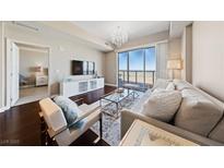 Bright living room featuring hardwood floors, modern furnishings, and sliding glass doors with mountain views at 8255 Las Vegas Blvd # 809, Las Vegas, NV 89123