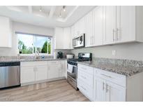 Bright kitchen featuring white cabinets, stainless steel appliances, and granite countertops at 8812 Marble Dr, Las Vegas, NV 89134