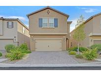 Charming two-story home featuring a two-car garage, brick driveway, and manicured landscaping at 9327 Ettrick Ct, Las Vegas, NV 89178