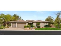 Charming single-story home with a three-car garage, manicured landscaping, and a lush green lawn at 1 Dry Brook Trl, Henderson, NV 89052