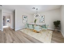 Bright dining room featuring stylish light fixture, oval table, and seating for eight at 1312 Pacific Terrace Dr, Las Vegas, NV 89128