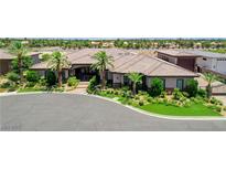 Beautiful single-story home with a tile roof, lush landscaping, and circular driveway at 8574 Verde Park Cir, Las Vegas, NV 89129