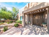 Inviting front entrance with landscaped yard and custom double doors, creating a warm welcome at 10445 Schirlls St, Las Vegas, NV 89141