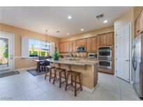 Bright kitchen boasts granite counters, stainless appliances, wood cabinets and a cozy breakfast nook at 12276 Caminita Pl, Las Vegas, NV 89138