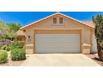 Home exterior featuring a two car garage door and desert landscaping at 2035 E Warm Springs Rd # 1019, Las Vegas, NV 89119