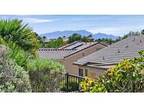 Beautiful house with a tile roof and solar panels in a lush green neighborhood with mountain views at 2548 Leighton Ave, Henderson, NV 89052