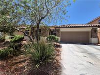 Charming single-story home featuring a stone facade, two-car garage, and mature landscaping at 6009 Arbor Crest St, North Las Vegas, NV 89081