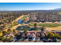 Stunning aerial view of homes bordering a golf course with water features and desert landscaping under a clear sky at 8713 Litchfield Ave, Las Vegas, NV 89134