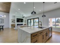 Gourmet kitchen with island, sleek counters, and views of the water and golf course at 8713 Litchfield Ave, Las Vegas, NV 89134