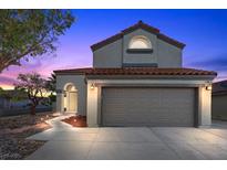 Charming two-story home with a well-manicured yard and a two-car garage at dusk at 2204 W San Miguel Ave, North Las Vegas, NV 89032