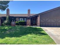 Charming single-story home with brick accents, a well-manicured lawn, and a two car garage at 6441 Brushwood Ln, Las Vegas, NV 89107