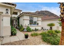 Charming single-story home featuring desert landscaping and a tiled roof with a mountain backdrop at 703 Jane Eyre Pl, Henderson, NV 89002