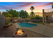 Inviting backyard with a sparkling pool, fire pit, string lights and comfortable patio space, perfect for outdoor entertaining at 741 Wildwood Beach Ave, Henderson, NV 89052
