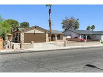 Single-story home with a spacious driveway, desert landscaping, and a charming gated front yard at 809 Greenbrook St, Las Vegas, NV 89110