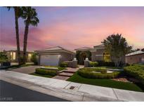 Charming single story home with manicured lawn and palm trees against a colorful sunset sky at 10331 Rio De Thule Ln, Las Vegas, NV 89135