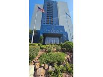 Low-angle exterior of Platinum Hotel & Spa building with blue facade, green foliage, and the US flag at 211 E Flamingo Rd # 405, Las Vegas, NV 89169