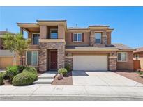 Inviting two-story home featuring stone accents, a two-car garage, and lush landscaping for curb appeal at 3609 Kingfishers Catch Ave, North Las Vegas, NV 89084