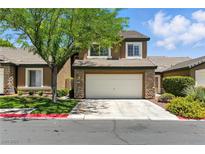 Inviting two-story home with a two-car garage, mature tree, and well-maintained landscaping at 620 Painted Cloud Pl, Las Vegas, NV 89144