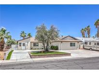Charming single-story home with landscaped yard and palm trees against a blue sky at 905 Smith St, Las Vegas, NV 89108