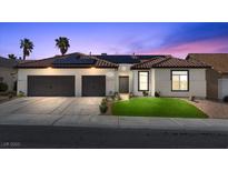 Charming home featuring a two-car garage, tile roof, solar panels, and well-manicured lawn at 9612 Glengarry Dr, Las Vegas, NV 89129