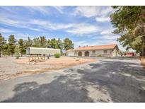 Spacious single-story home with a long driveway, carport, and low maintenance desert landscaping at 1050 Morgan Ln, Pahrump, NV 89060