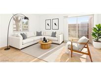 Bright living room with a neutral color palette, a large sectional, and a sliding glass door to the patio at 3668 Villa Knolls East Dr, Las Vegas, NV 89120