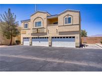 Three-story home featuring three garage doors and a tan stucco exterior, under a bright blue sky at 4020 Smokey Fog Ave # 3, North Las Vegas, NV 89081