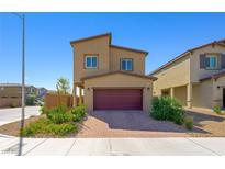 Two-story home with a well-kept yard and a two-car garage, showcasing modern architecture in a residential neighborhood at 7730 Moore Creek Ln, North Las Vegas, NV 89084
